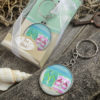Beach themed flip flop design key chain with a clear glass dome